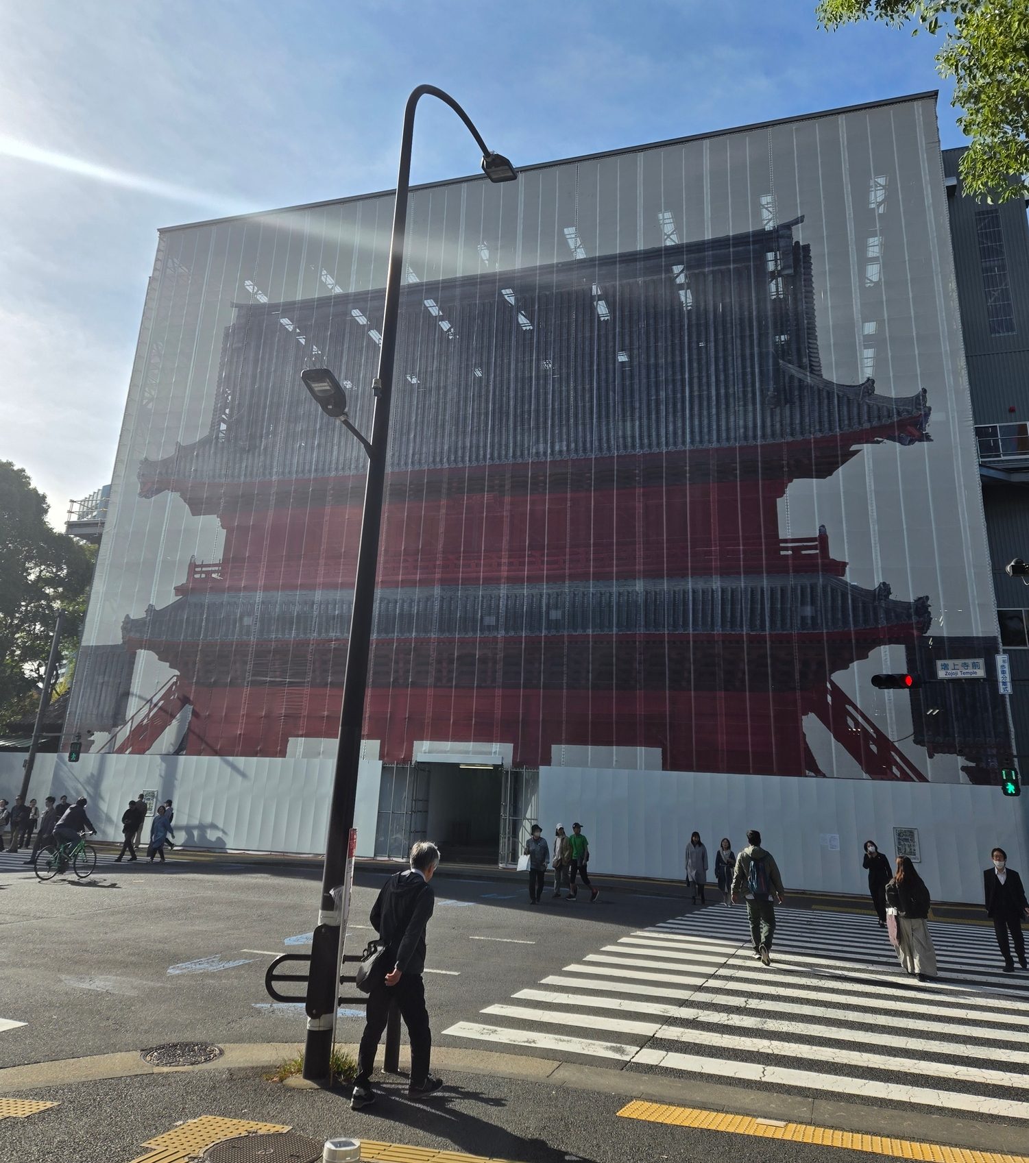 A photo of a construction site wall that is printed to look like a temple gate!