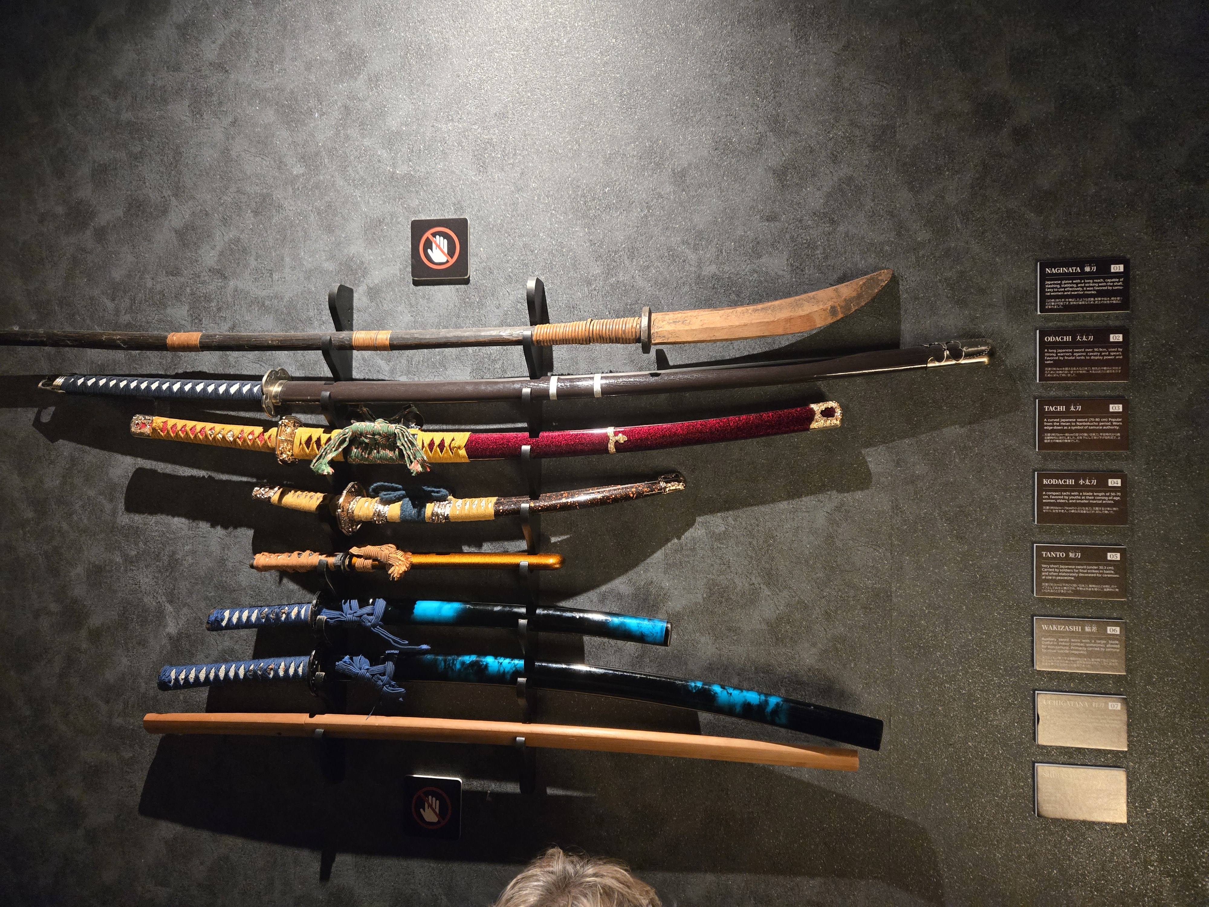 A wall-mounted display showing a variety of samuari sword types.