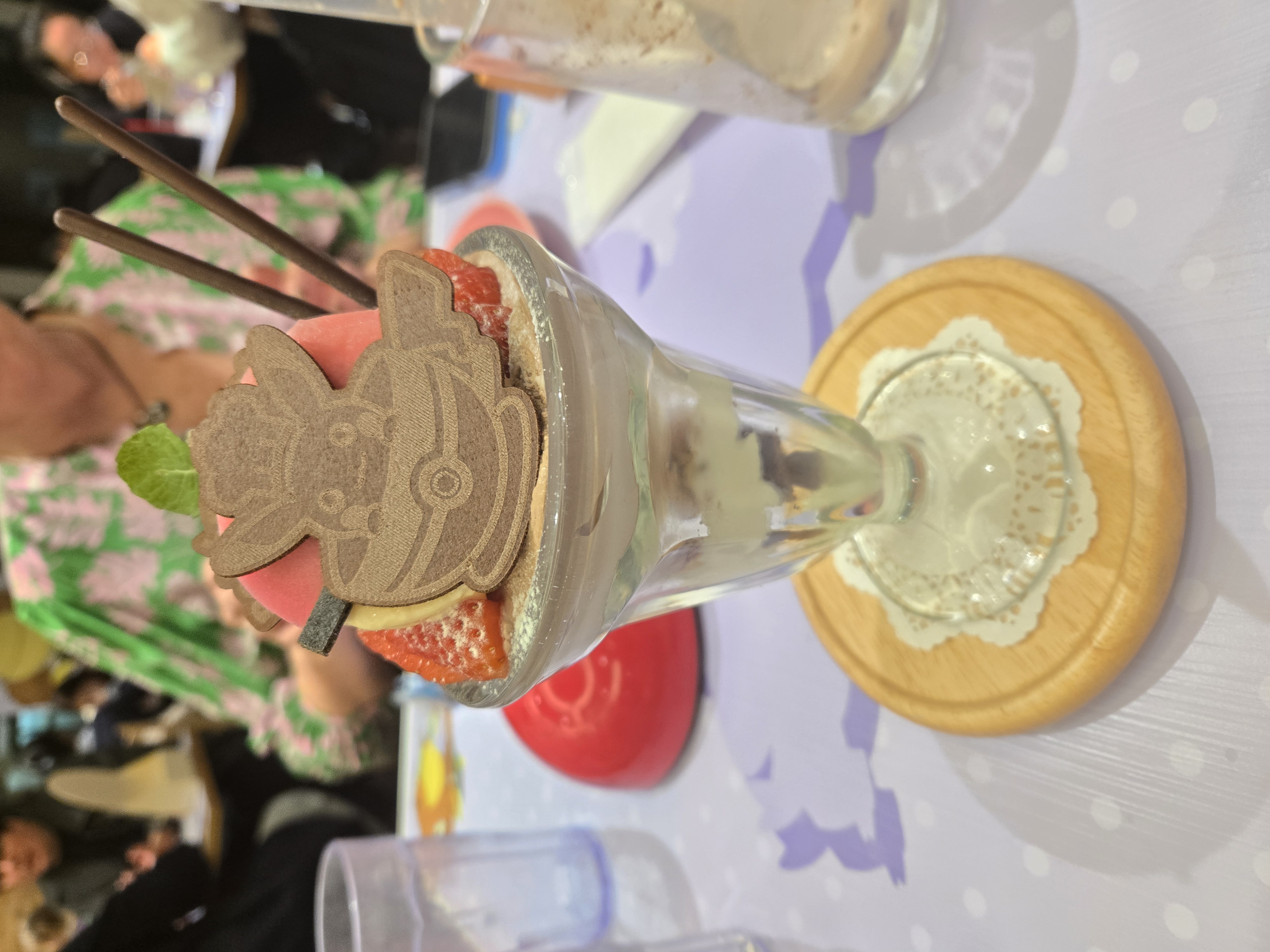 A photo of the fancy Pokemon Cafe dessert - a glass full of layers of different desserts.