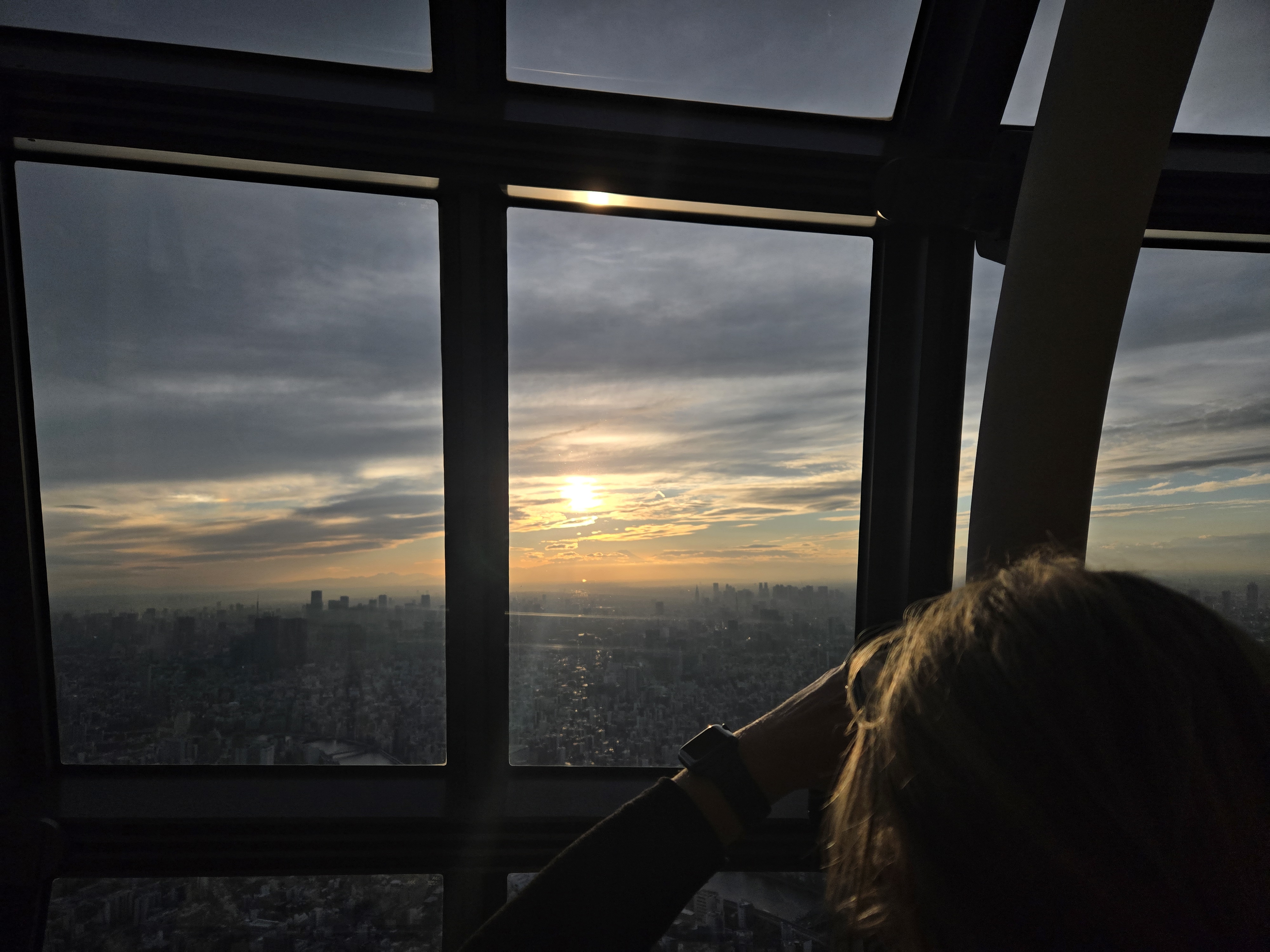 A photo of a city skyline, with the sun glaring at us.