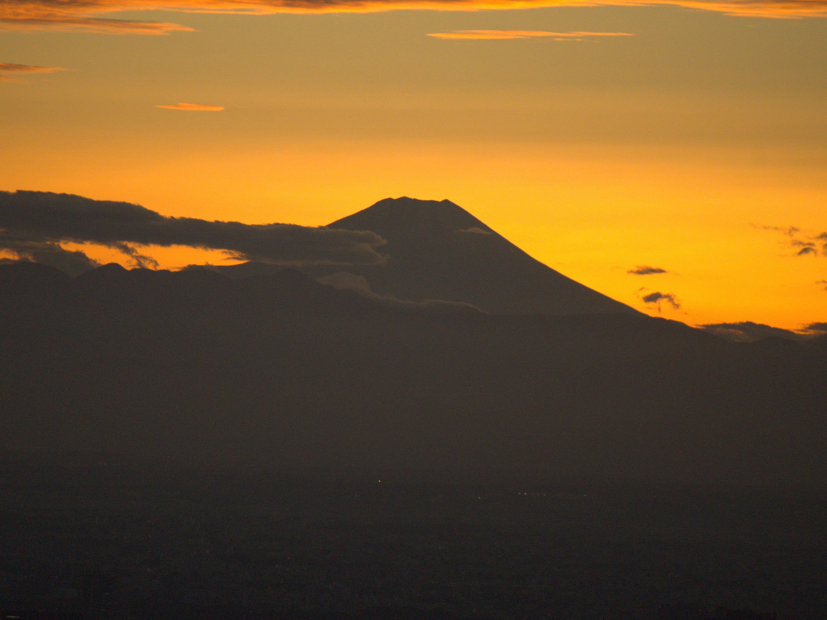 A photo of a city skyline, with the mountains and Mt Fuji visible.