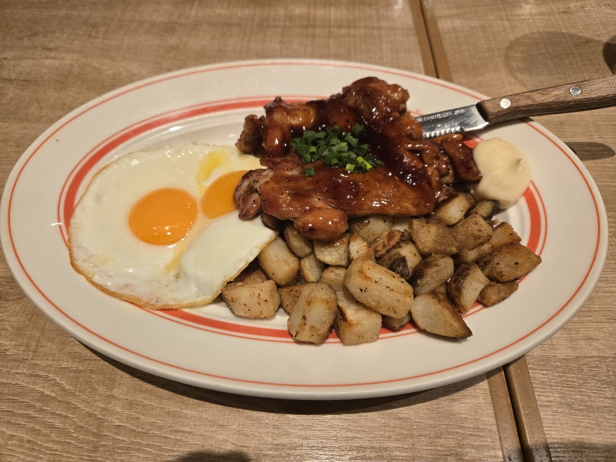 A photo of a meal: teriyaki chicken, wedges, and eggs.