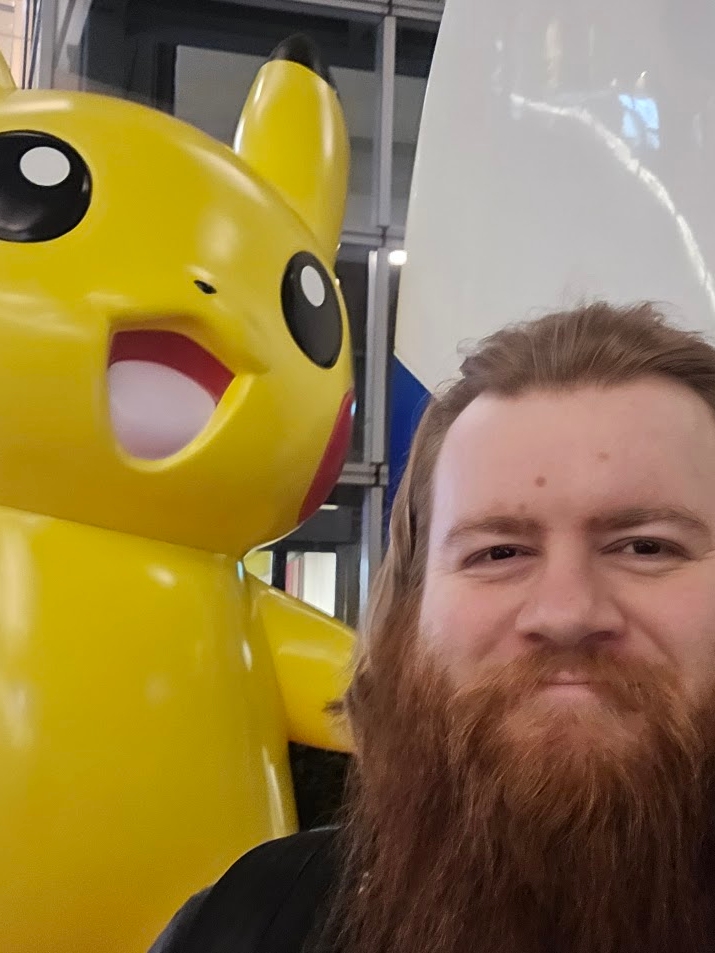 A photo of the Tokyo Bay Pokemon statue, feating a Pikachu standing next to and holding a surfboard.